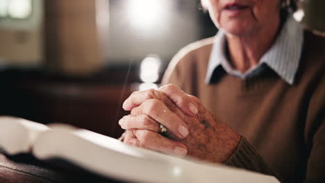 senior woman praying in church with hands clasped