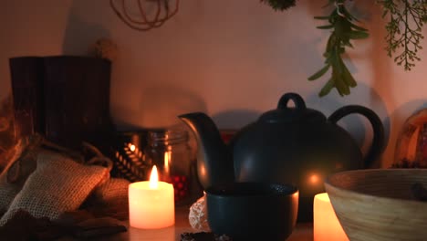 relaxing background detail shot of an herbal tea shop, with candles with flickering flames, a tea pot, a cup with steam coming out, herbs hanging, books, and some dust flying around