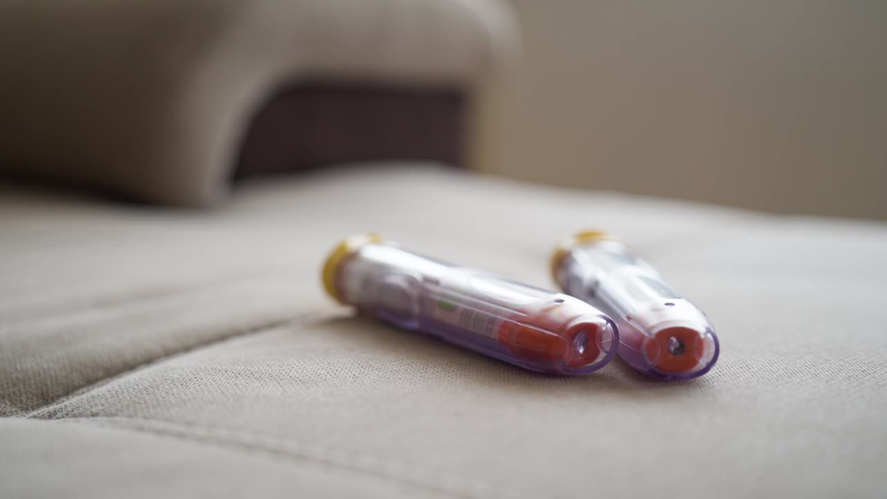 dos autoinyectores de epinefrina en un sofá