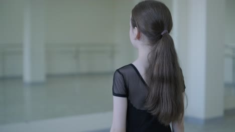 young ballerina practicing dance moves in studio