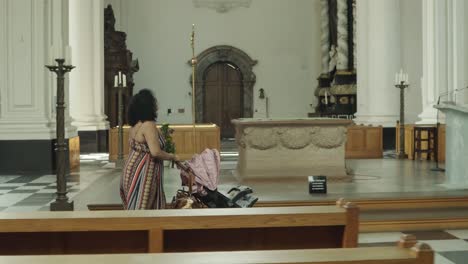 beautiful black lady walking in the church with her new born