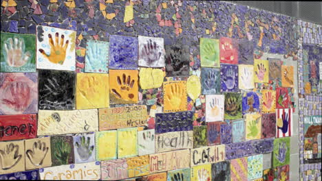 colorful mosaic wall with ceramic handprint tiles
