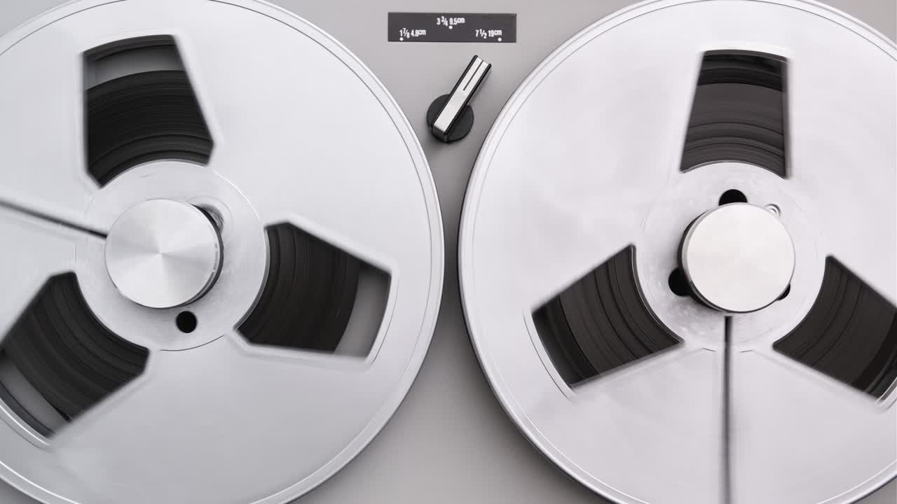 to reel tape recorder jugando. rotando el reproductor de música vintage de cerca. cinta retro. girando los carretes de color metálico. vista desde arriba. tendencias populares de la discoteca de los años 60s, 70s, 80s, 90s.