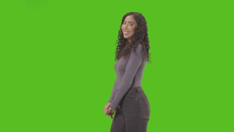 portrait of woman against green screen smiling and laughing at camera 1