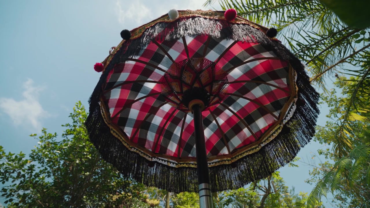 Ombrello tradizionale balinese Umbul-Umbul contro un cielo tropicale