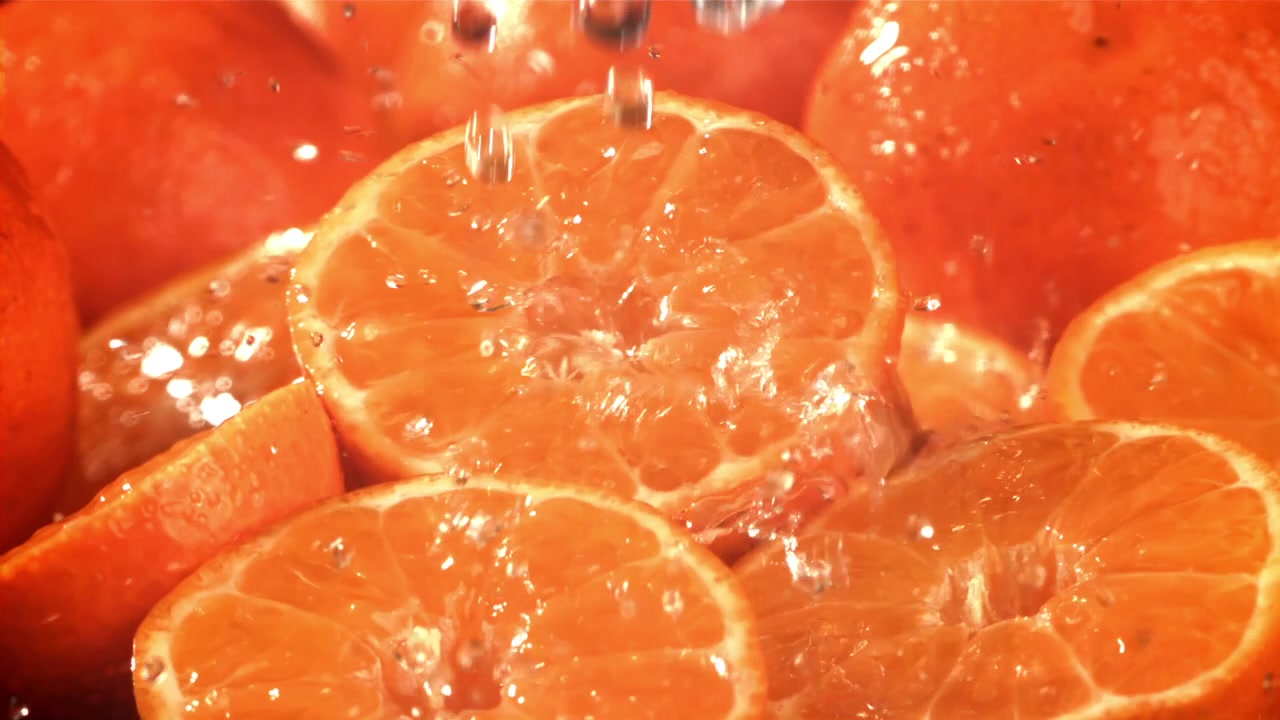 Acqua che schizza su metà di mandarino fresco al rallentatore