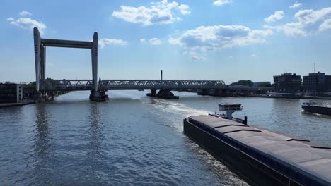 barges in holland pass under the famous dordrecht railway bridge