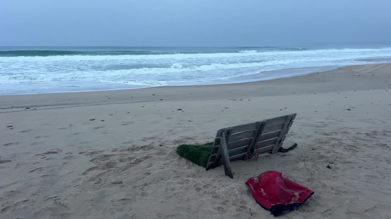 변덕스럽고 흐린 하늘 아래 외로운 해변, 강력한 파도가 해안으로 몰아치고 있어요