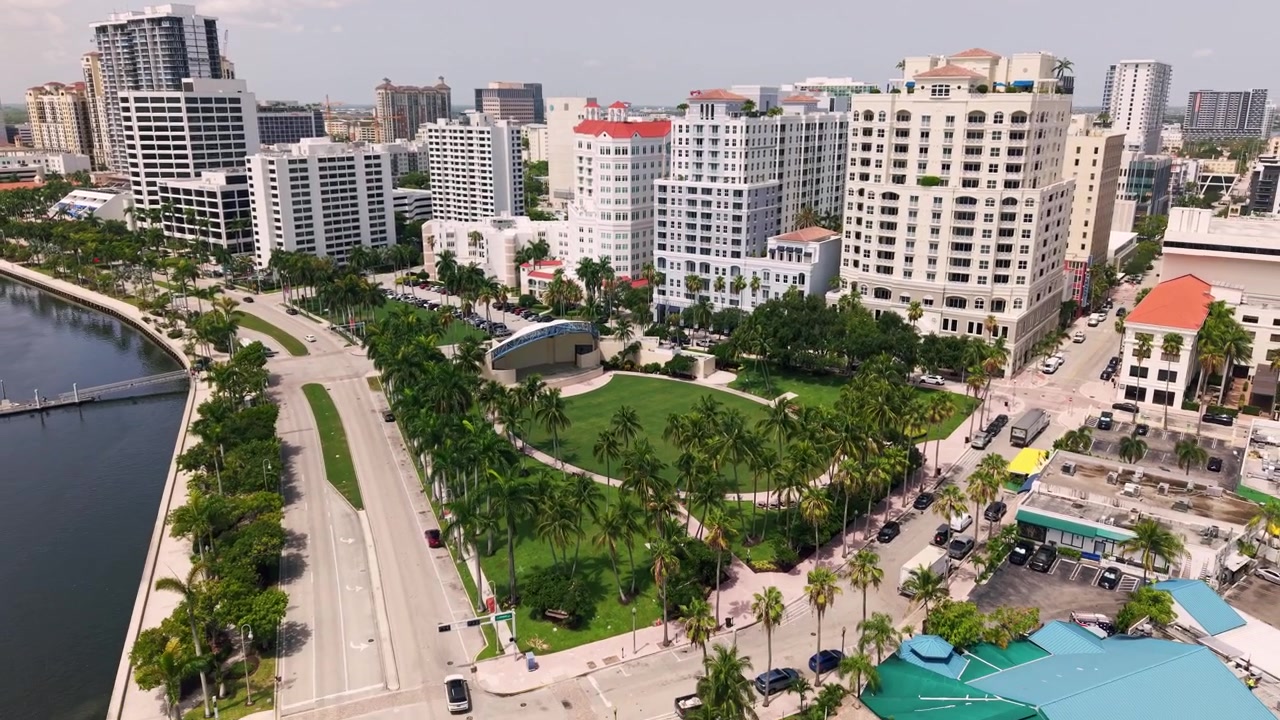 Vista aerea: panorama urbano del centro di West Palm Beach con palme di giorno in Florida, USA, ripresa con drone in allontanamento
