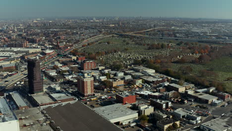 Los-Delanteros-Vuelan-Por-Encima-De-Los-Suburbios.-área-Alrededor-Del-Cementerio-Histórico-Del-Gran-Calvario.-Concurrida-Carretera-Principal-De-Varios-Carriles-Que-Conduce-A-Lo-Largo.-Reinas,-Ciudad-De-Nueva-York,-Estados-Unidos