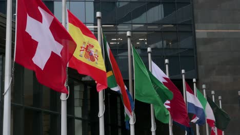 Nationalflaggen-Der-Schweiz,-Spaniens,-Südafrikas,-Saudi-arabiens,-Jordaniens,-Neuseelands,-Italiens,-Hongkongs-Und-Chinas-Wehen-In-Hongkong-Im-Wind