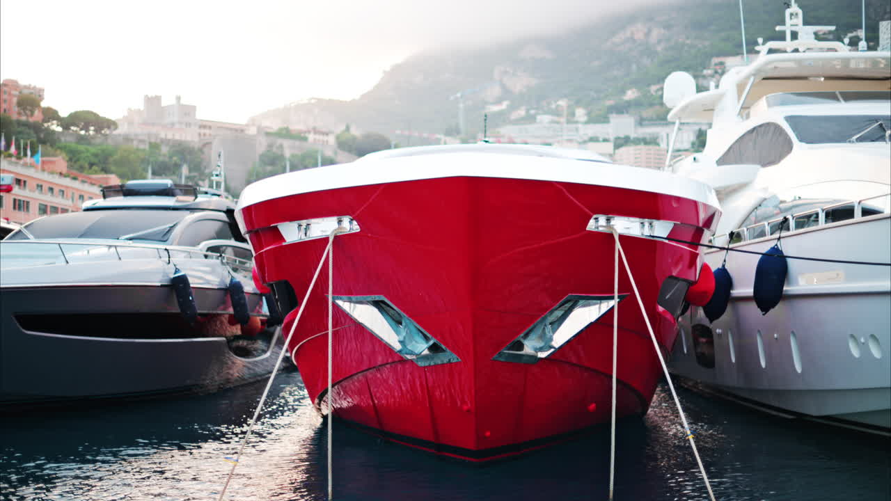 View of boats docked in the Monaco Marina with the skyline of the city on the background
