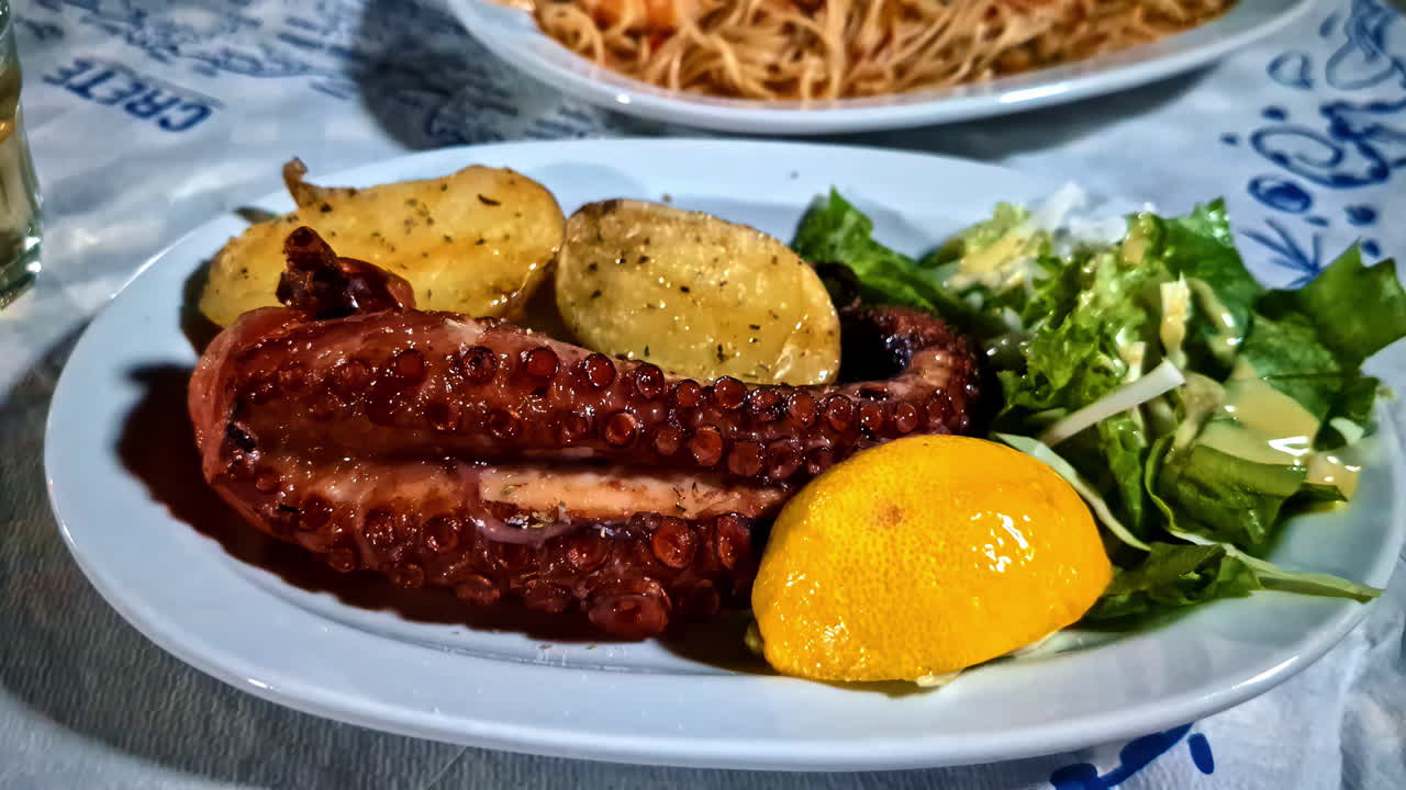 Octopus leg dish with potatoes served on table for dinner. Zoom out