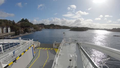 sailing electric ferry hjellestad in beautiful sunny weather along norway coastline - camera facing forward against bow and sailing direction onboard ship