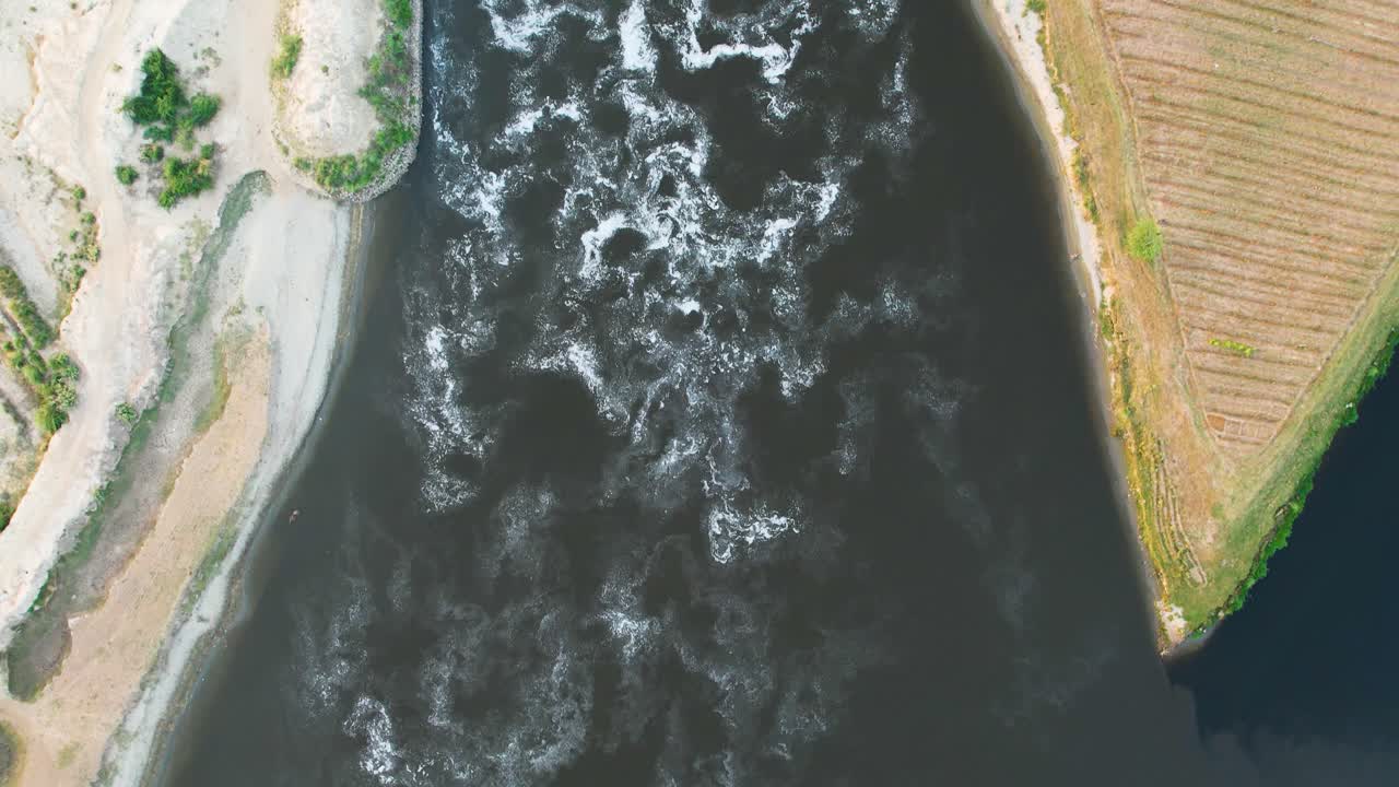 Top-down view of turbulent Sutlej River cutting through farmland near the border region. Punjab, Pakistan