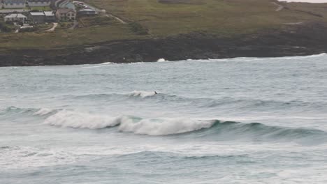 hand-held shot of a surfer attempting to surf a wave at fistral beach