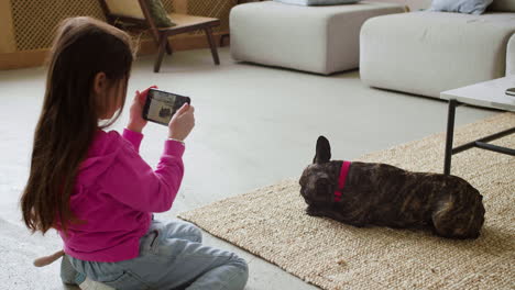 girl taking pictures of dog