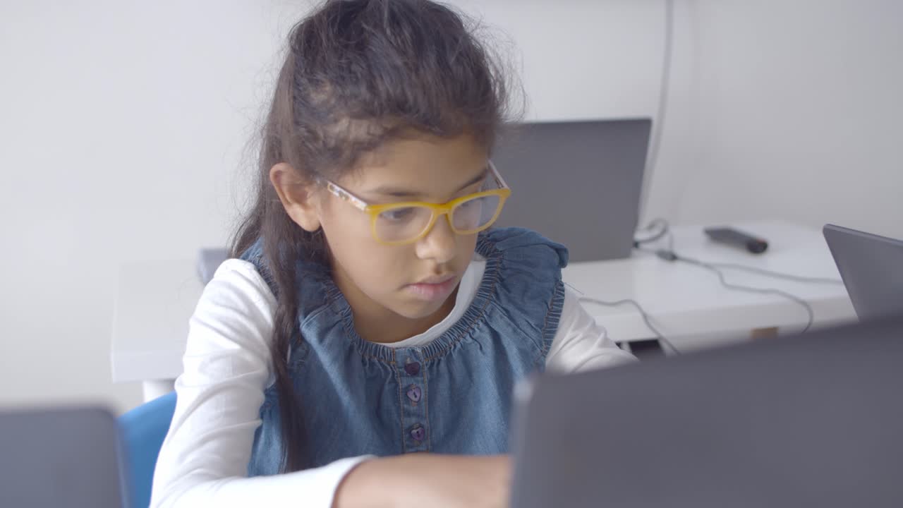 una estudiante inteligente con gafas sentada en un escritorio