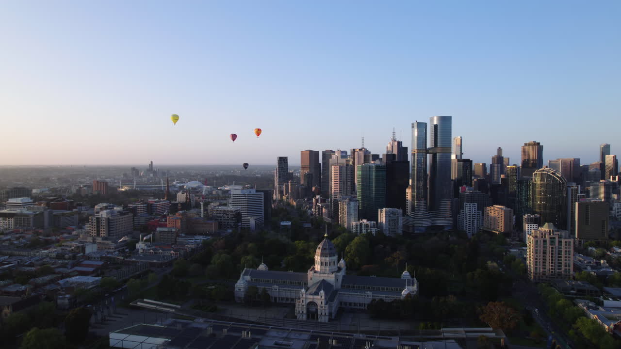 Aerial view over the Royal Exhibition Building with Hot air balloons above the city