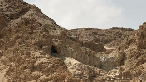 zoom in on a cave in the hills at qumran in israel