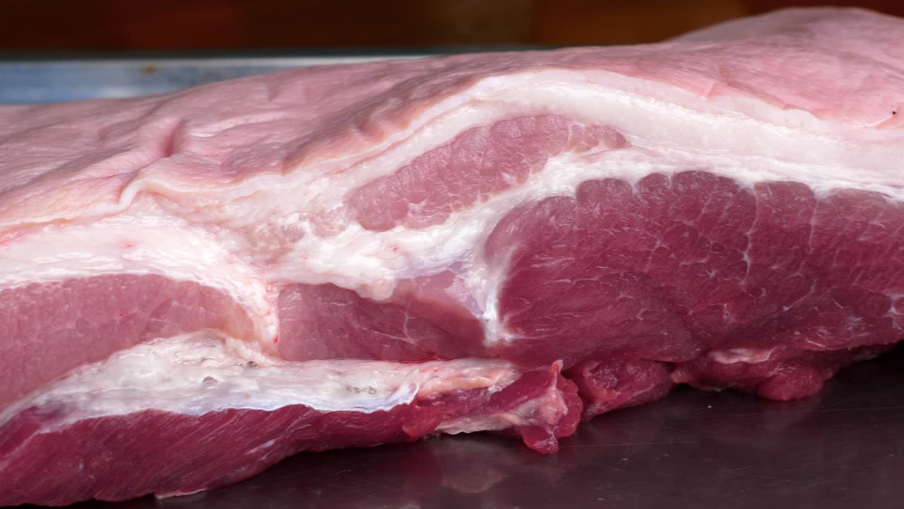 Carne de barriga de porco crua e bonita sobre a mesa antes de cozinhar.