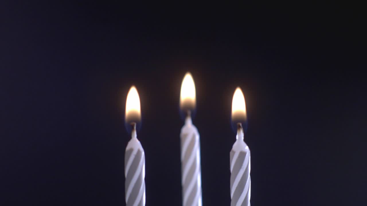 Tre candele accese isolate su sfondo nero. - primo piano