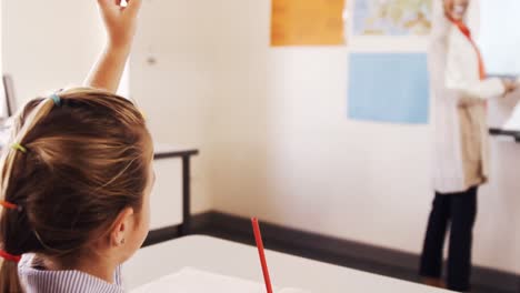 school kids raising hand in classroom