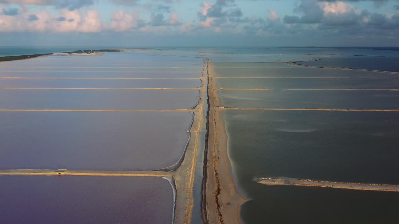 amplia vista aérea de lagos rosados separados por arena en las coloradas en méxico durante la puesta de sol