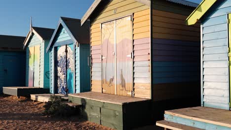 brightly painted beach huts on sandy shore