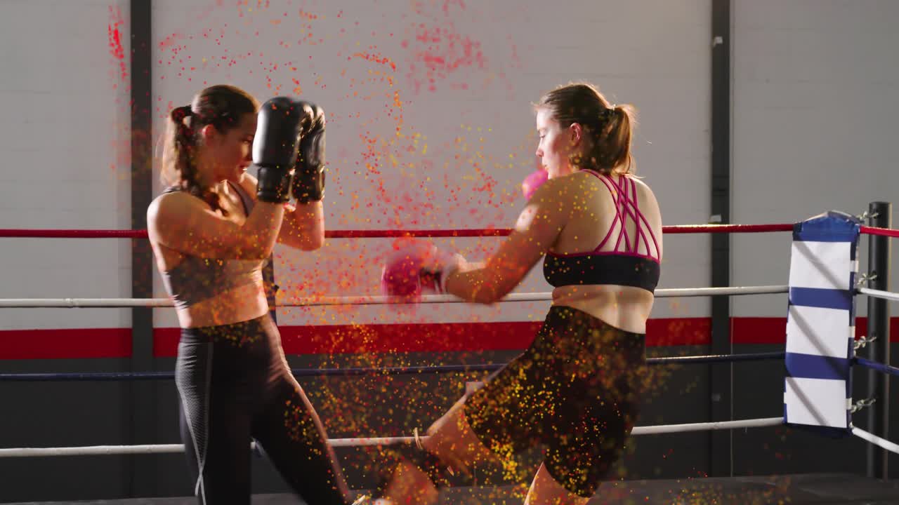 Two female fighters trading strikes in boxing ring, contact sparking orange bursts during sparring
