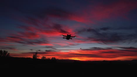 drone flying with colorful sky at sunset. drone in night flight with position lights flashing. aerial view in orbit. spain.