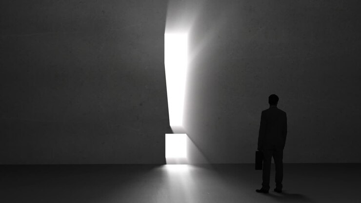 Businessman looking at giant exclamation mark