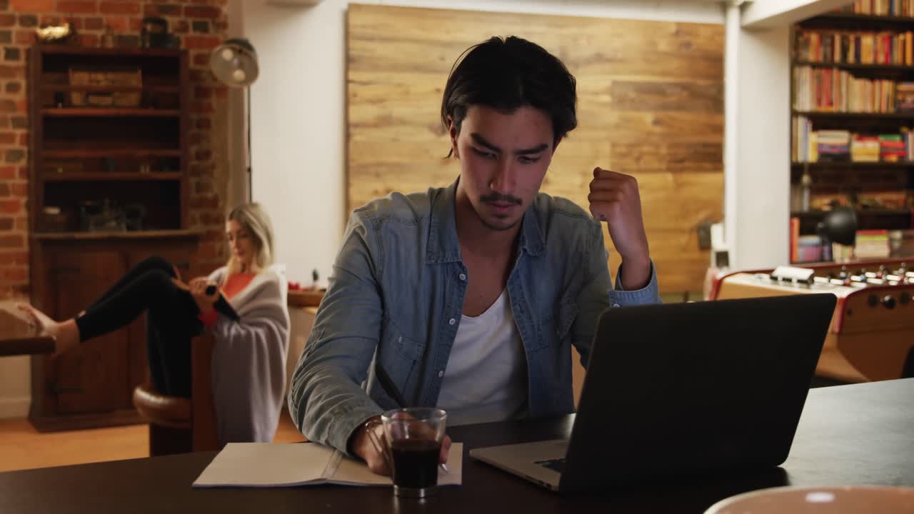 Uomo di etnia mista concentrato e al lavoro nel suo appartamento