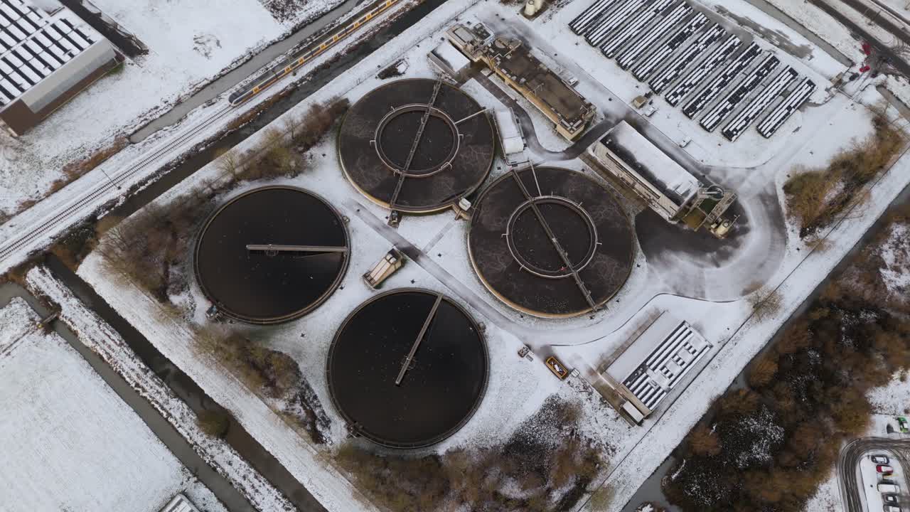 Perfectly symmetrical aerial view of wastewater treatment basins in winter conditions, emphasizing geometry, industrial design and environmental infrastructure