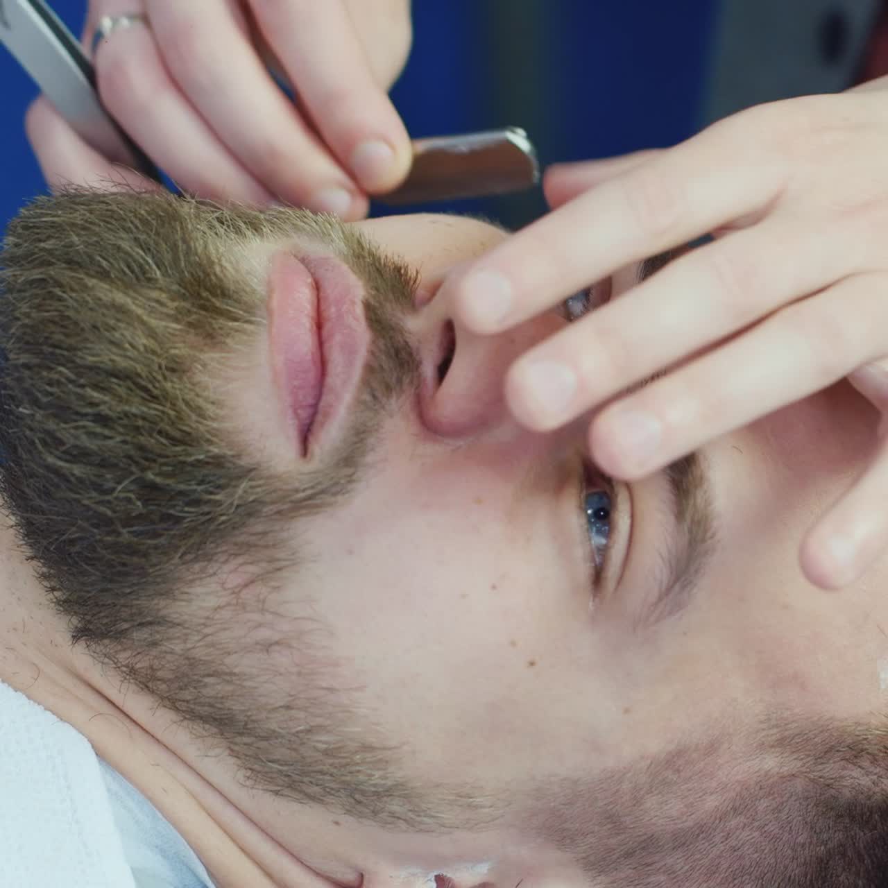 수염을 자르기 위해 면도날을 사용하는 이발사 02