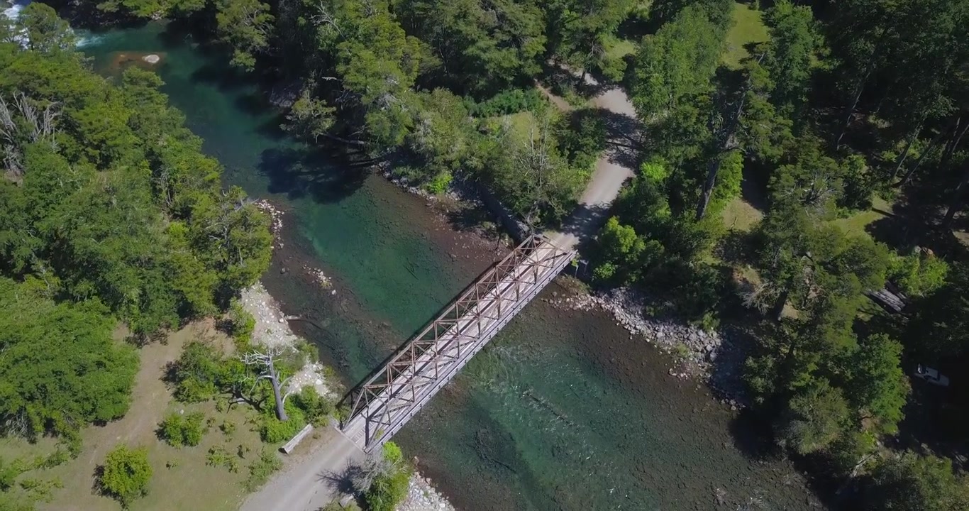 Volo perfetto con drone su un campo che raggiunge il fiume e si può vedere il vecchio ponte metallico che lo attraversa