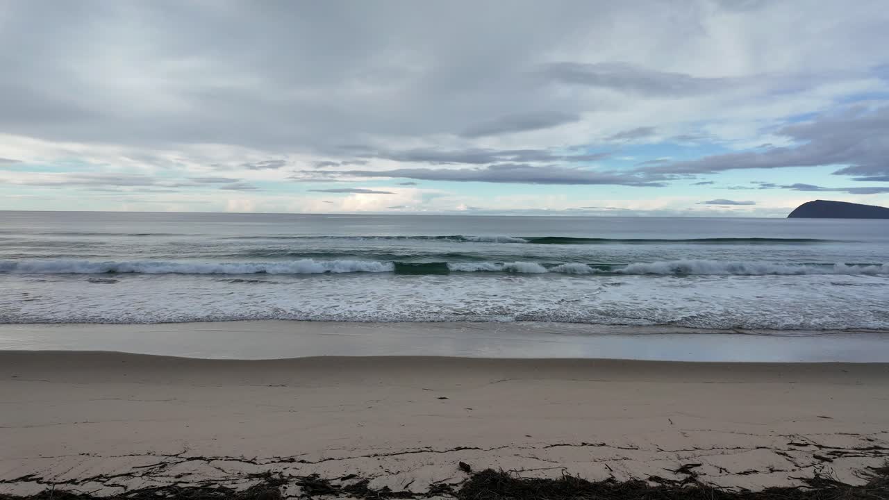 Serene Beach Landscape with Calm Waves and Cloudy Sky