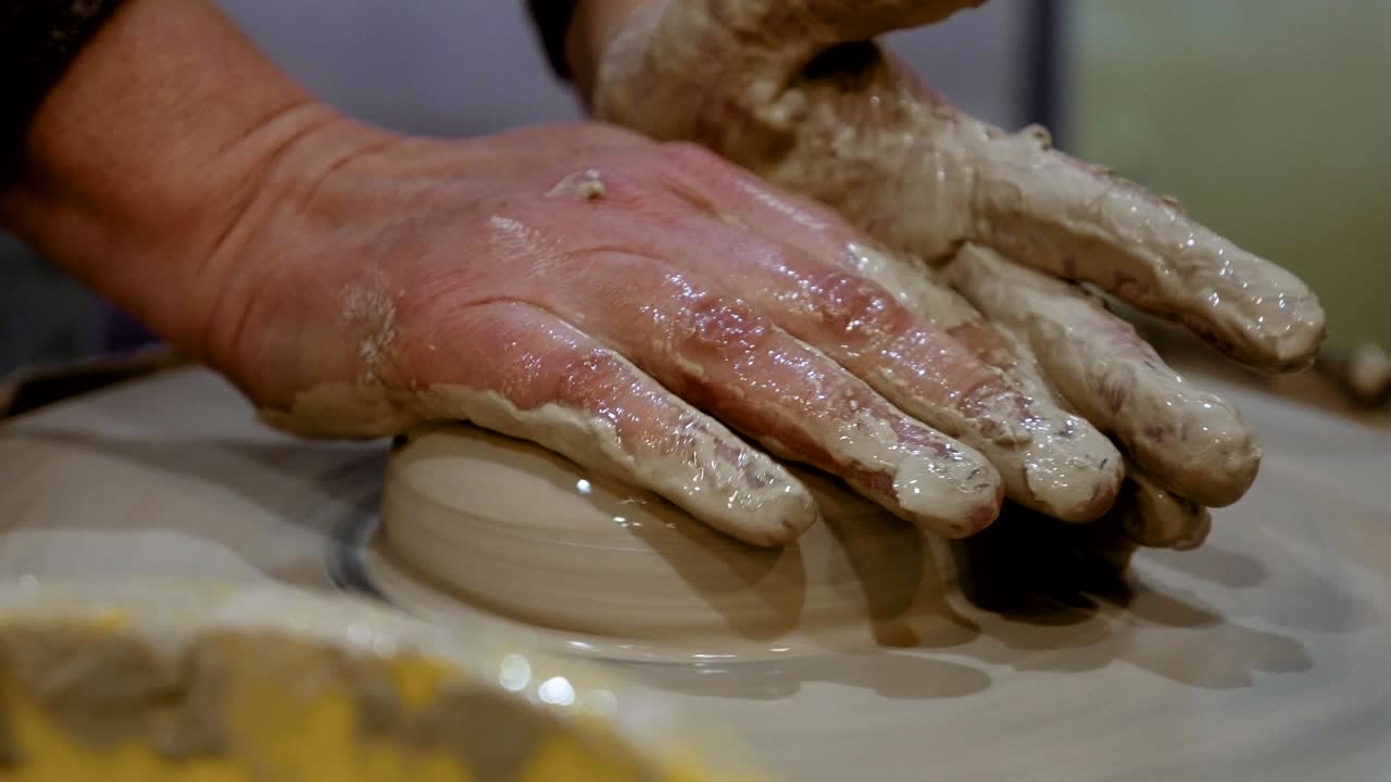 Potter is making clay pot on the potter's wheel