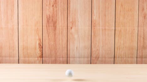 a golf ball moves across a wooden floor