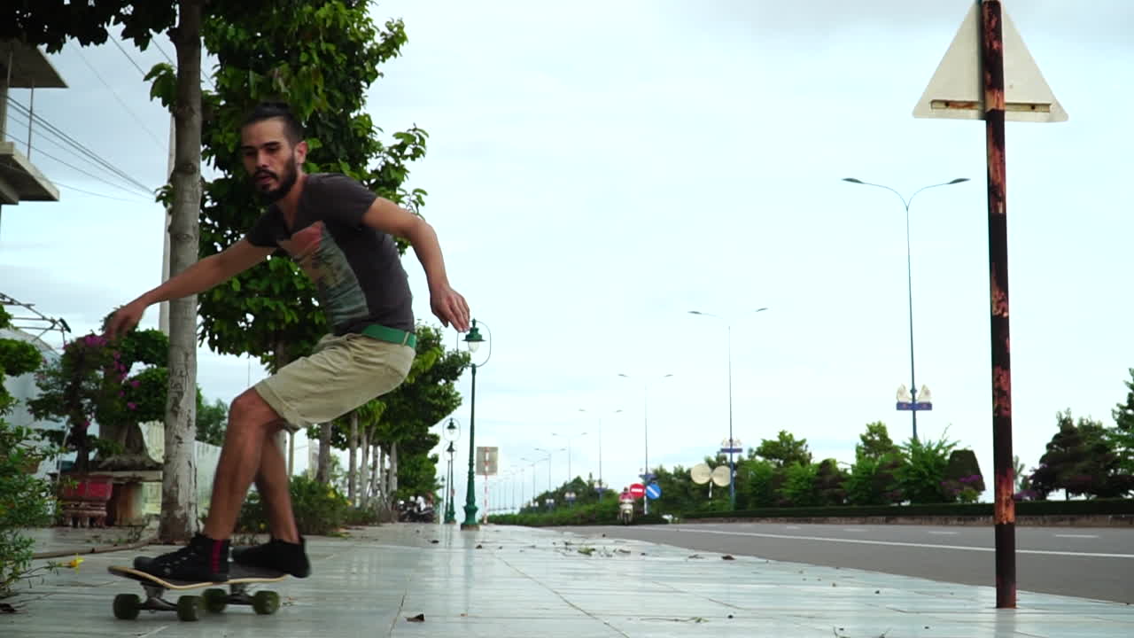andar en patineta, el hombre monta patineta y hace trucos de tallado y giro en la calle