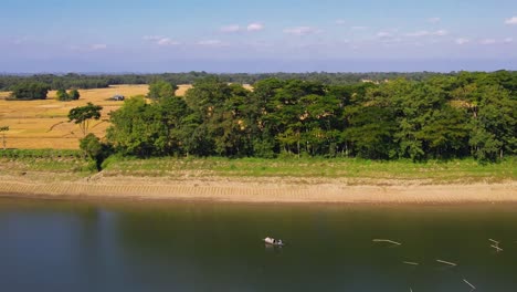 Aerial-drone-view-of-fisherman-on-board-of-fishing-boat-in-Surma-River,-Sylhet