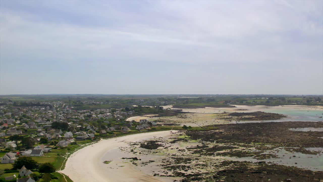 Coastal village near Brest, Brittany, showcasing sandy beaches, extensive tidal flats, and scattered rocks along the Atlantic shoreline. Captured from above. Drone DJI