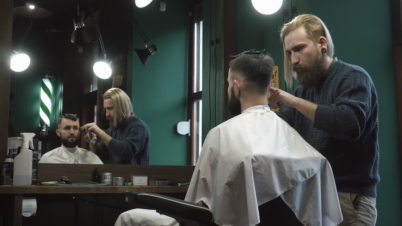 Barber klipper kundens hår i en barbershop