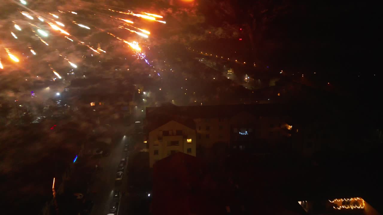 el dron captura una deslumbrante exhibición de fuegos artificiales que iluminan el cielo nocturno durante las celebraciones de fin de año, creando una atmósfera espectacular y festiva