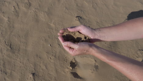 Picking-up-sahara-sand-in-Morocco-and-letting-it-slip-through-his-fingers