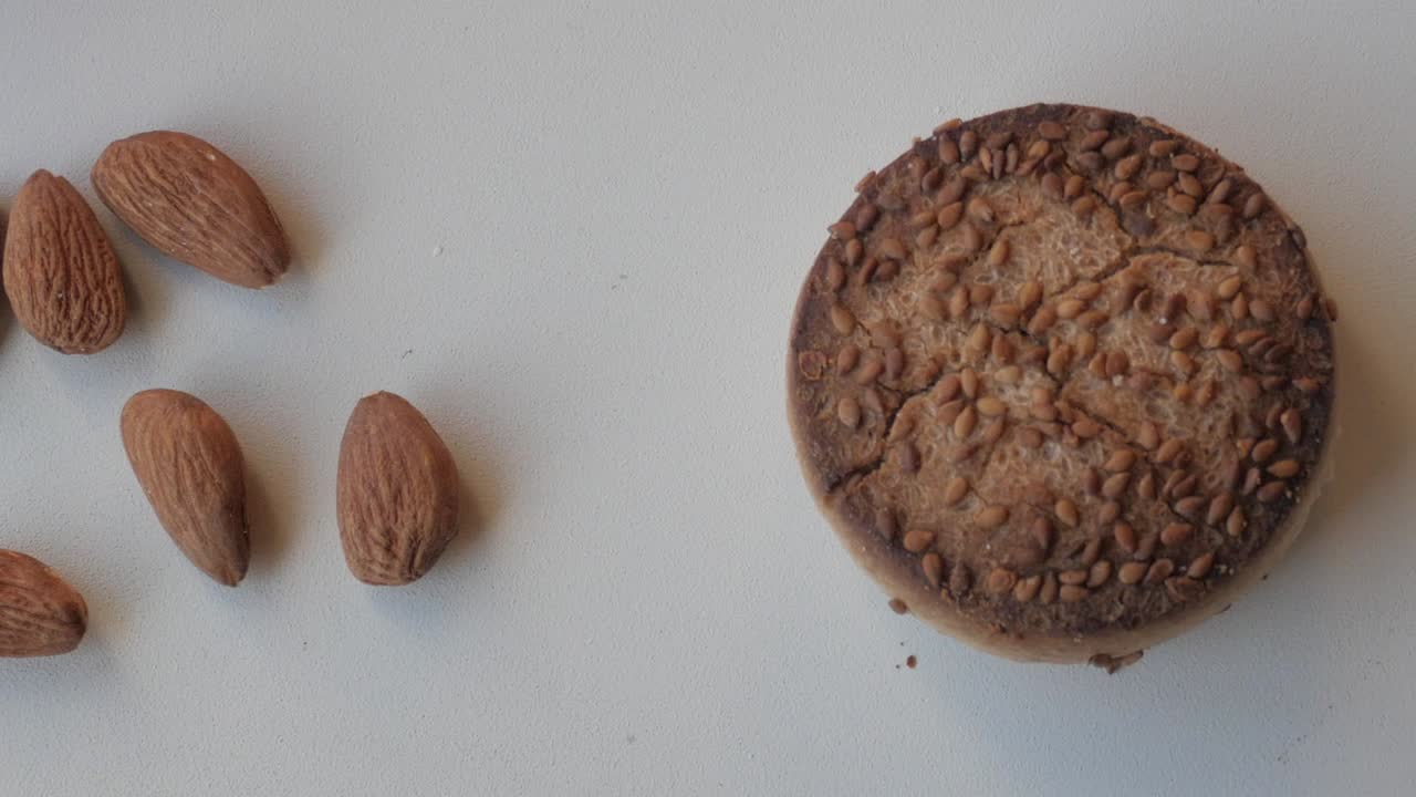 스페인의 크리스마스 과자, 맨테카도 (mantecado) 의 클로즈업, 아몬드와 전통적인 둥근 페이스트리가 색 표면에 있습니다.