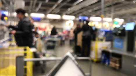 blurred: people stand at self-service workstations, cash in the store