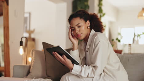 young woman looking at tablet on couch