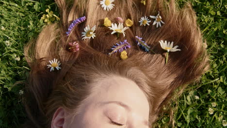 woman with flowers in her hair lying in a grassy meadow