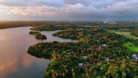 Cottages located in the tropical woods near the peaceful river. Overcast sky at backdrop. Aerial perspective.